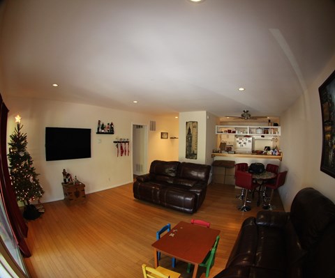 A living room with a Christmas tree and a bar area.