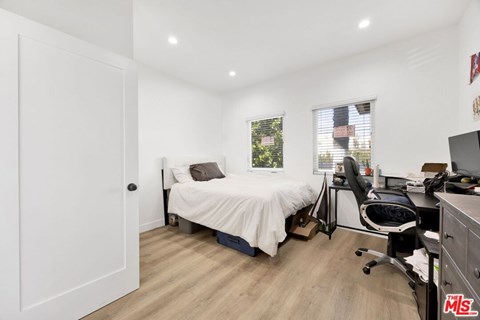 A bedroom with a bed, desk, and chair.