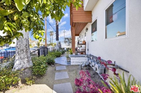 A white house with a garden in front.