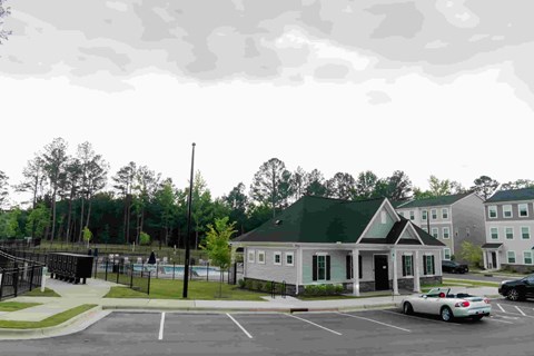 A parking lot with a building and a car.