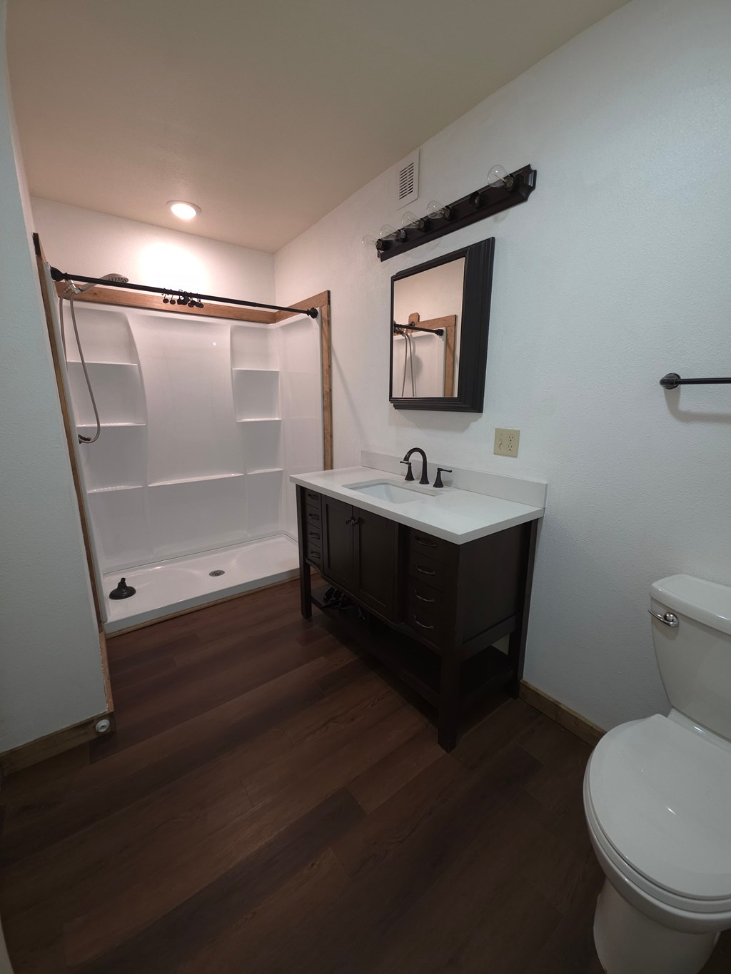A white toilet sits next to a sink in a small bathroom.