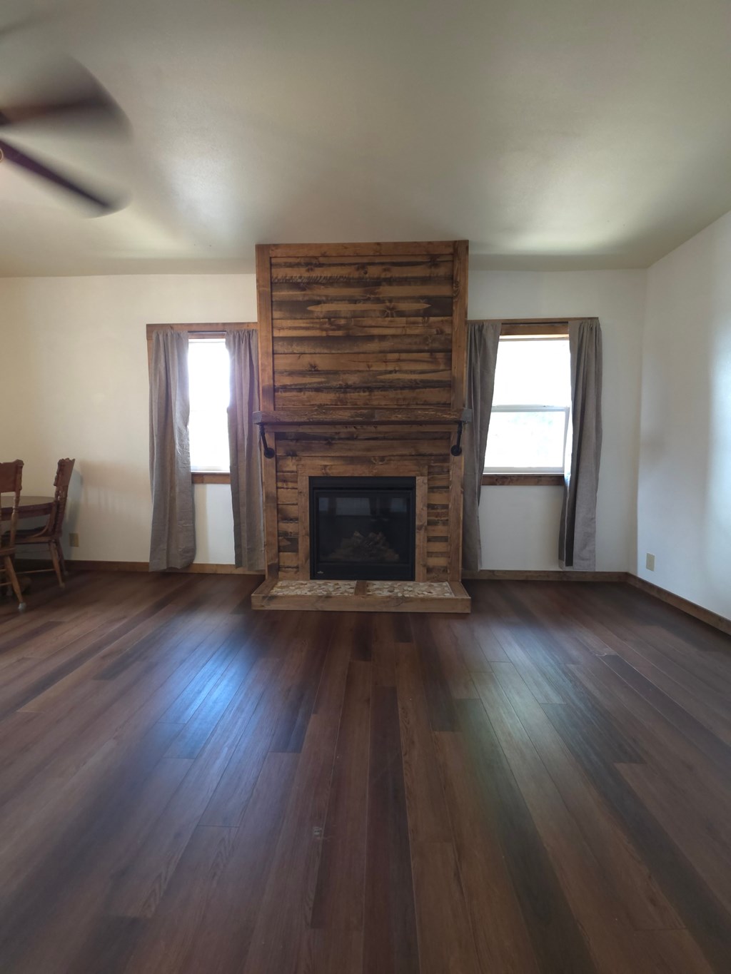 A room with a fireplace and wooden floors.
