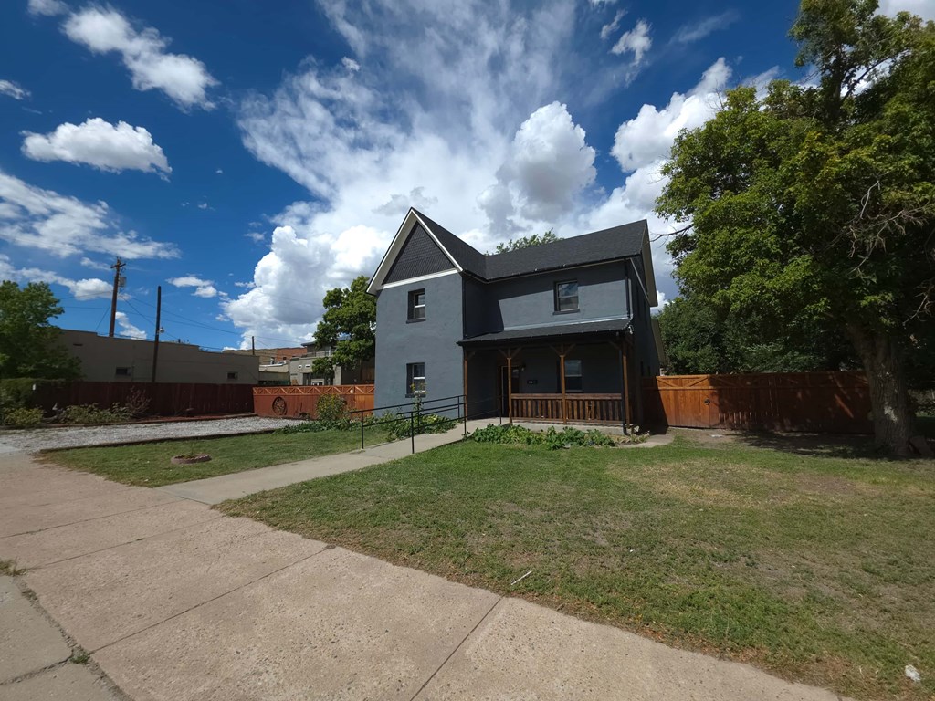 A house with a grey roof and a brown fence.