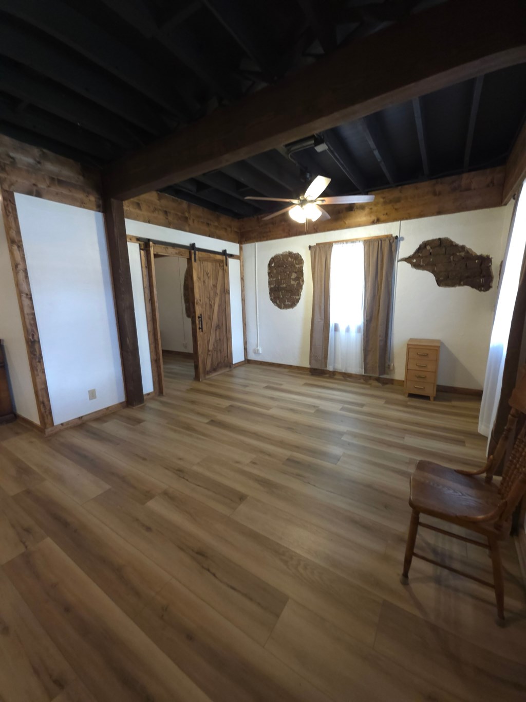 A room with wooden floors and a ceiling fan.