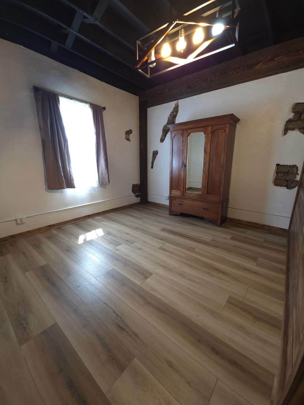 A room with wooden floors and a wooden cabinet.