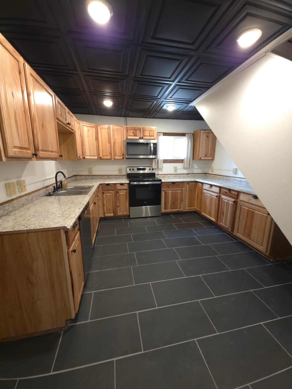 A kitchen with wooden cabinets and a black stove top oven.