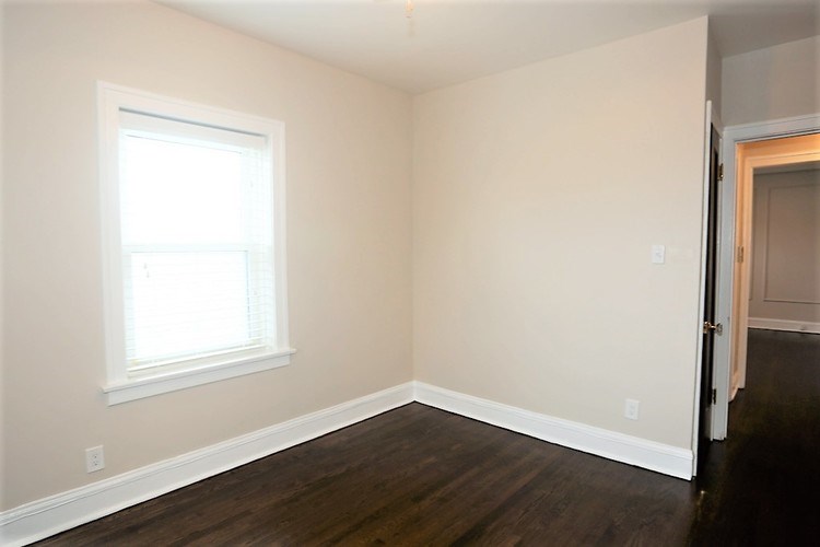 A room with a window and wooden floors.