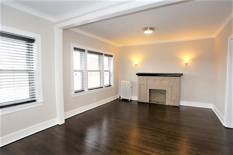A room with a fireplace and a window with blinds.