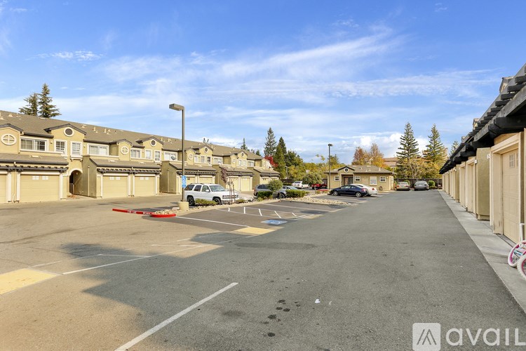 A street view of a residential area with houses and parked cars.