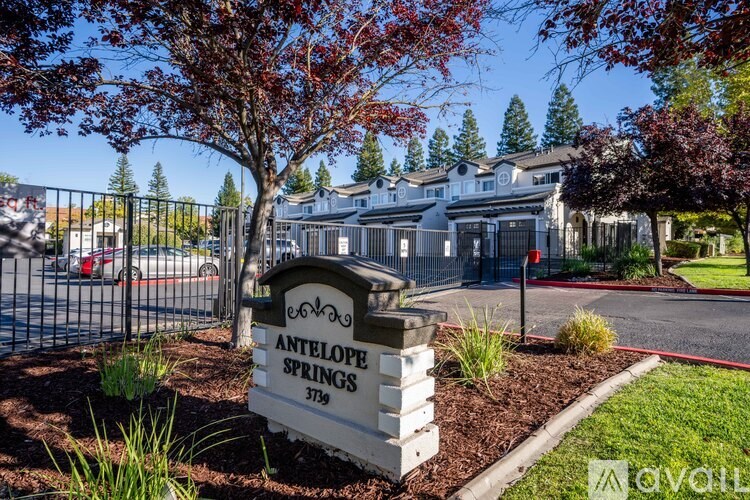 A sign for Antelope Springs stands in front of a gated community.