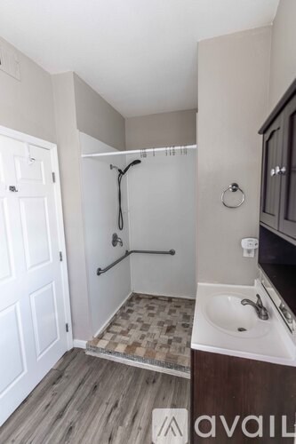 A room with a wooden floor and a window with blinds.