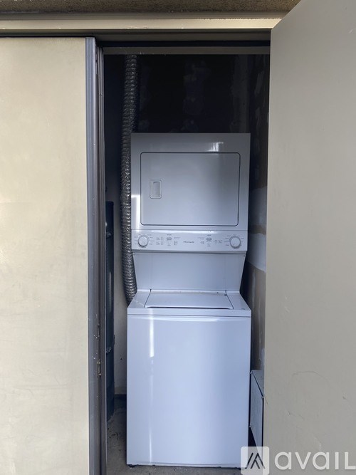 A white dishwasher and microwave are in a small space.