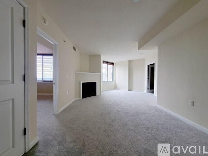 A spacious living room with a fireplace and a door leading to another room.