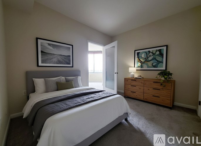 A room with a carpeted floor and a door leading to a bright area.