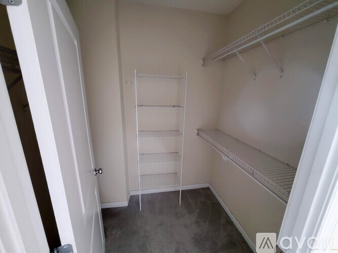 A small, empty room with a white door and a white shelf.