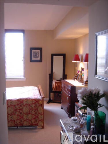A bedroom with a bed, dresser, and mirror.