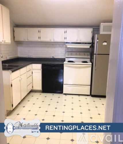 A kitchen with black countertops and white appliances.