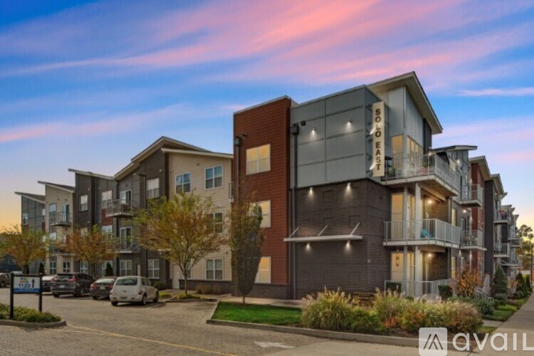 A modern apartment complex with a parking lot in front.