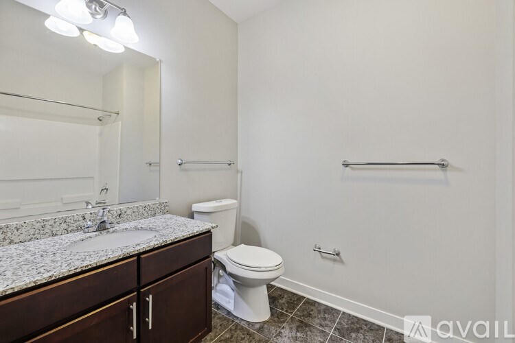 A bathroom with a toilet, sink, and a mirror.