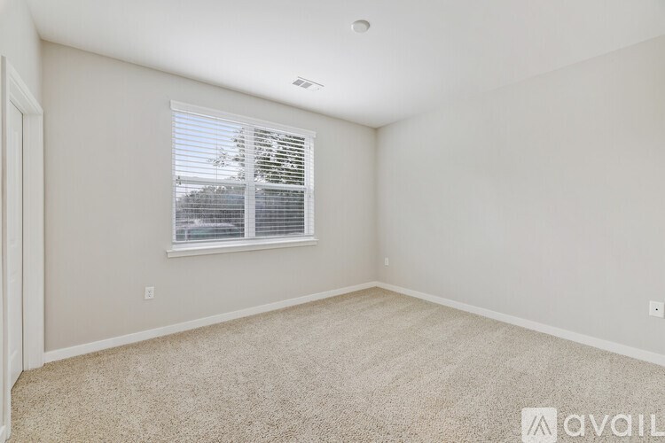 A room with a window and carpeted floor.