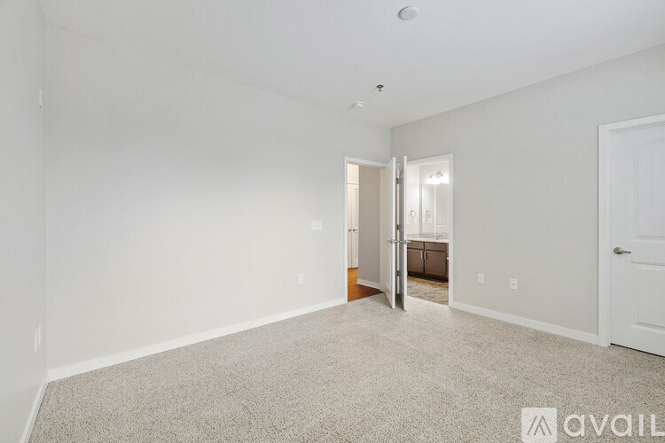 A spacious room with a carpeted floor and a door leading to another room.
