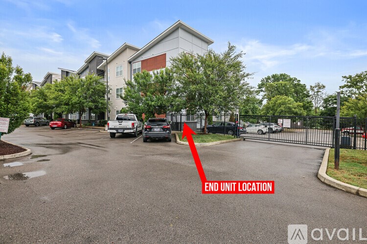 A parking lot with a red arrow pointing to the end unit location.