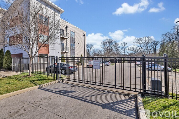 A black metal gate blocks the entrance to a parking lot.