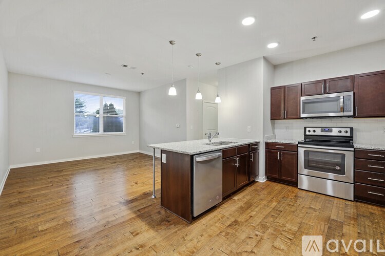 A kitchen with wooden floors and stainless steel appliances is available for rent.