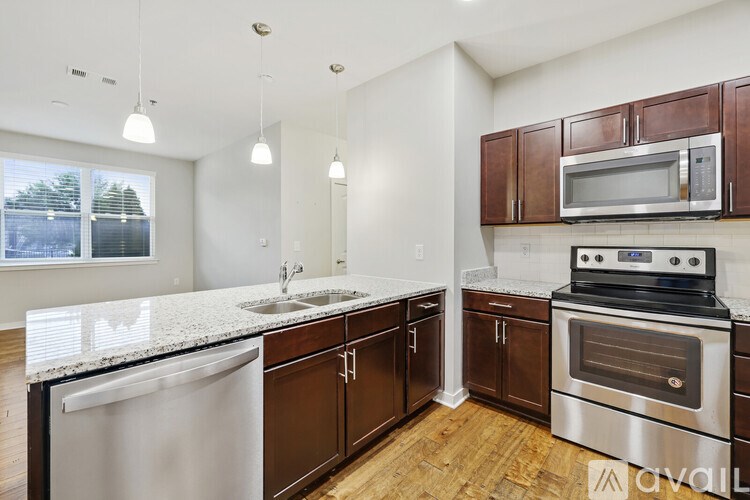 A kitchen with brown cabinets and stainless steel appliances.