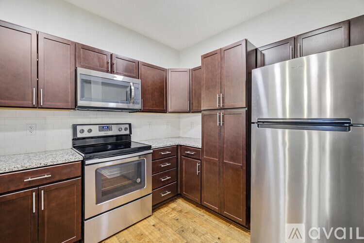 A kitchen with wooden cabinets and a stainless steel refrigerator.