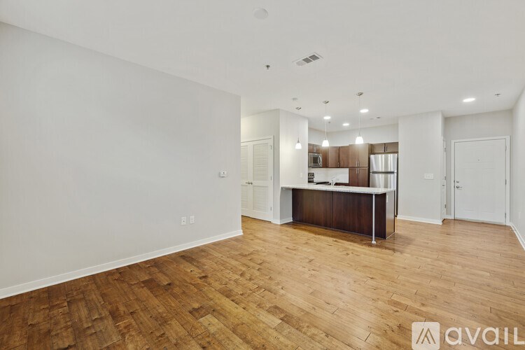 A spacious room with wooden flooring and white walls.