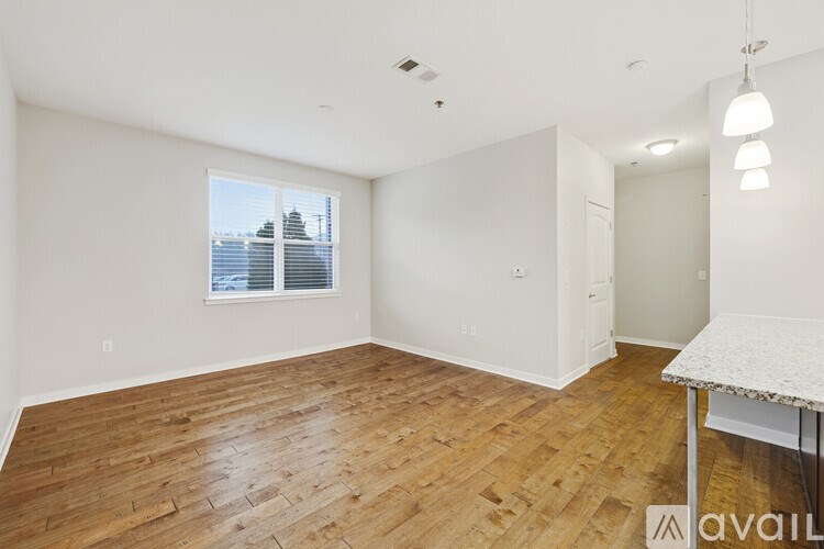 A room with wooden flooring and a table with a white tablecloth.