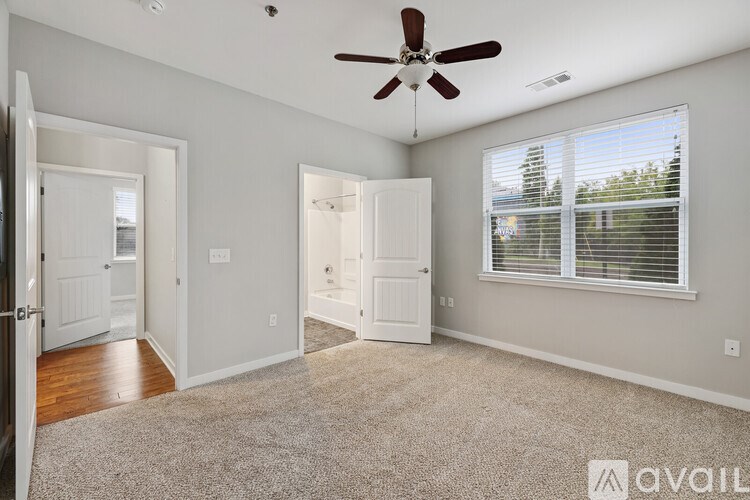 A room with a ceiling fan and a carpeted floor.