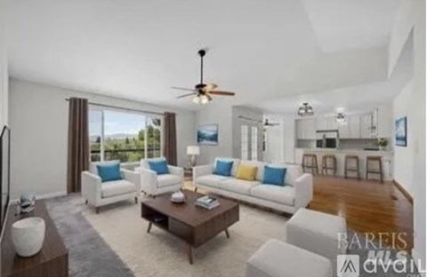 A living room with a white couch and a ceiling fan.