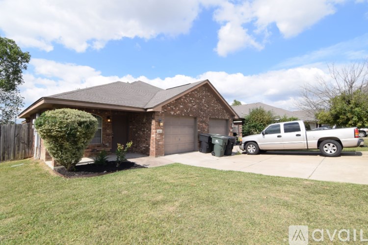 A house with a garage and a car parked in front.