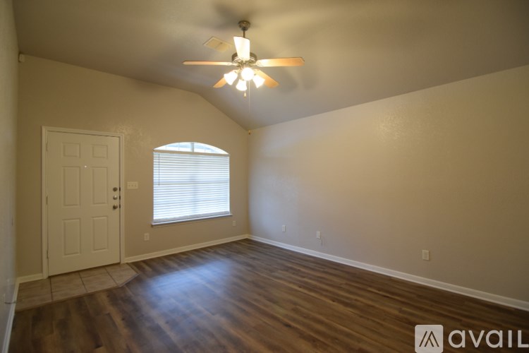 A room with a ceiling fan and a window with blinds.
