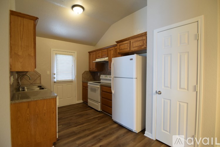 A kitchen with wooden cabinets and a white refrigerator.