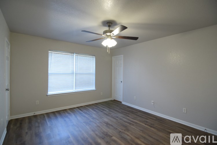 A room with a ceiling fan and a window with blinds.