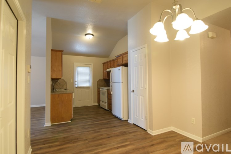 A kitchen area with a refrigerator, sink, and cabinets.