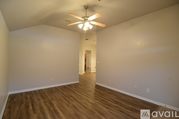 A room with wooden floors and a ceiling fan.