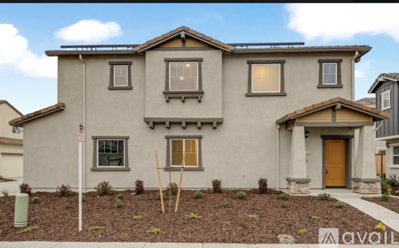 A house with a brown door and windows with brown frames.