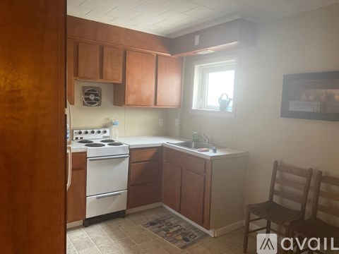 A kitchen with wooden cabinets and a white stove.