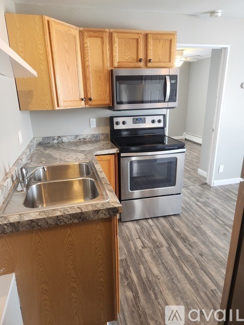 A kitchen with a stove, oven, microwave, and sink.