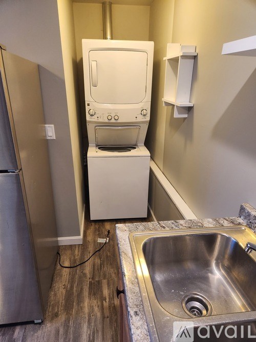 A stainless steel refrigerator sits next to a white dishwasher in a kitchen.