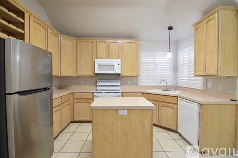 A kitchen with wooden cabinets and a white refrigerator.