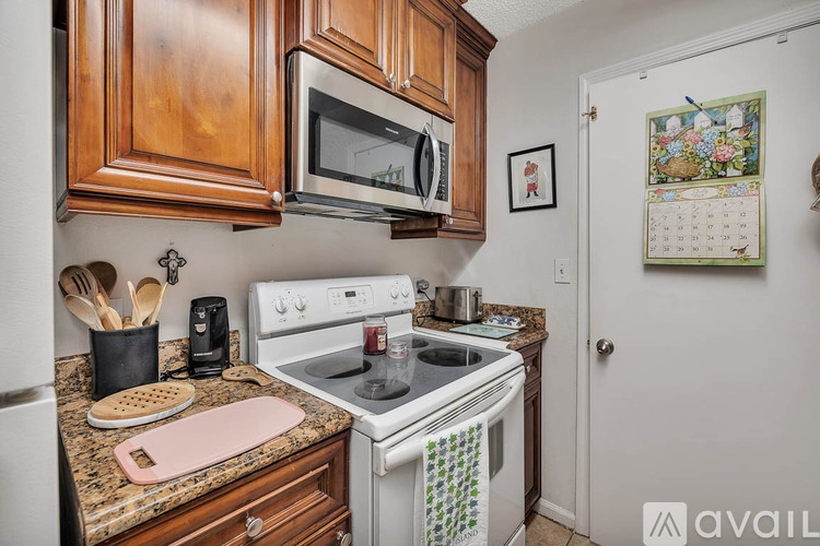 A kitchen with a white refrigerator and a sink.