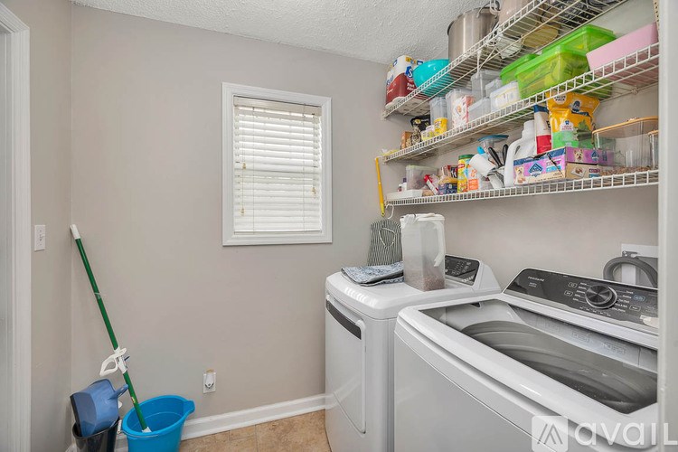 A room with wooden floors and two windows with blinds.