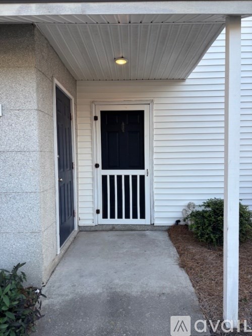 A white house with a black door and a small porch.