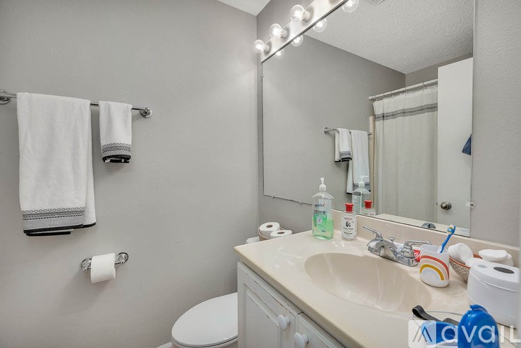 A bathroom with a white toilet, sink, and towel rack.