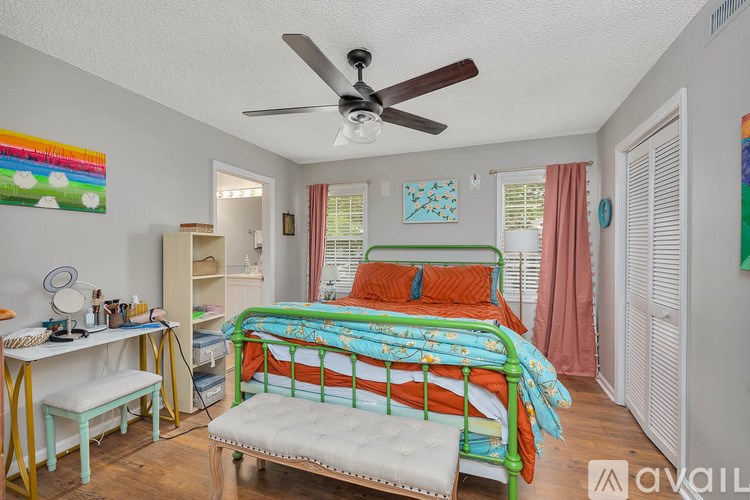 A bedroom with a bed, desk, and chair.